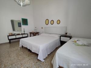1 Schlafzimmer mit 2 Betten und 2 Spiegeln an der Wand in der Unterkunft Mamma Assuntina in Lecce
