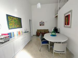 ein Esszimmer mit einem weißen Tisch und Stühlen in der Unterkunft Mamma Assuntina in Lecce + 8 Fotos
