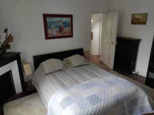 Un dormitorio con una cama y un cuadro en la pared. en Alliances & Missions Médicales, en Versalles