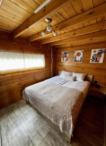 una camera da letto con un letto in una cabina di legno di Blisko Natury - domki w Sztutowie a Sztutowo