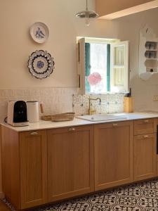 a kitchen with wooden cabinets and a sink and a window at Jardim de Cascais in Cascais +136 photos