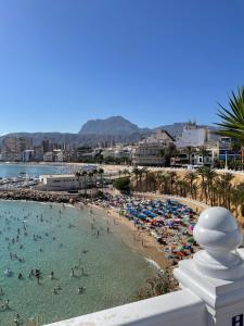 a beach with a bunch of people in the water at Apartamentos Pelicano in Benidorm
