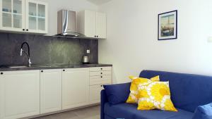 セリネにあるApartments Bonacaの青いソファとキッチンのあるリビングルーム