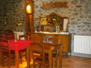 una sala da pranzo con tavolo e orologio di Casa Rural Cal Xico ad Adrall