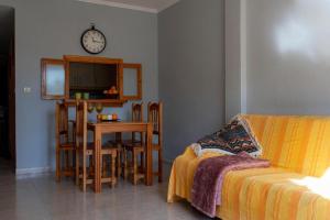 a bedroom with a table and a table and a clock at Casa Amy - Zona Naturista in Playas de Vera