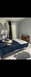a bedroom with a bed with blue sheets and a table at Maison familiale ou entre amis à la campagne in Nanthiat