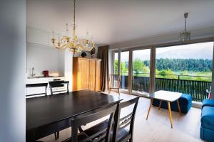 a dining room with a table and a large window at Seehaus Herzog in Drobollach am Faaker See