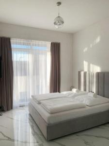 a white bedroom with a large bed and a window at Silver Moon Residence 3 in Arad +7 photos