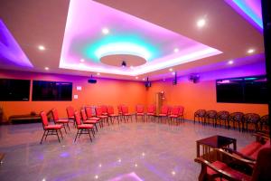 a room with red chairs and a stage with purple lights at Hillsidecreek Homestay in Anachal
