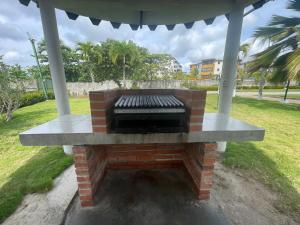 a brick fireplace in a yard with a gazebo at Alcaravanes 1 in Higuerote