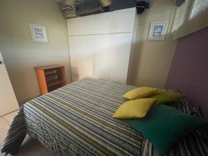 a bedroom with a bed with yellow pillows on it at Alcaravanes 1 in Higuerote +12 photos