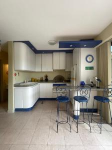 a kitchen with white cabinets and bar stools at Alcaravanes 1 in Higuerote