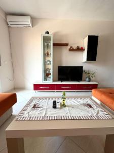 a living room with a table and a tv at Sea view appartment lungomare in Vlorë