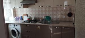 a kitchen with a sink and a washing machine at Gusar goust house int in Qayakǝnd