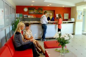un grupo de personas sentadas en un restaurante en Olimpiska Centra Ventspils Hotel, en Ventspils