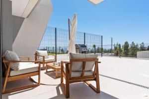 un patio con 2 sedie e un divano sul tetto di ViVi Homes - Marisol Pool, Sauna, Gym, Spa & Beach a Mijas Costa