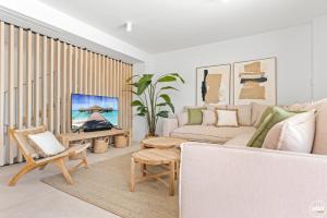 a living room with a couch and a tv at ViVi Homes - Marisol Pool, Sauna, Gym, Spa & Beach in Mijas Costa