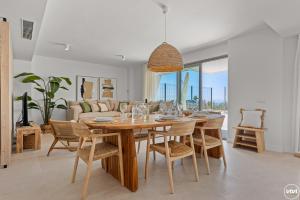 una sala da pranzo con tavolo, sedie e divano di ViVi Homes - Marisol Pool, Sauna, Gym, Spa & Beach a Mijas Costa