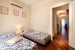 a bedroom with two beds and a hallway at La Villetta delle Stelle in Viareggio