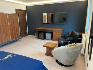 a living room with a tv and a couch and a chair at Pension Beyoglu Galata in Stolberg