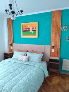 a bedroom with a bed with a blue wall at Jazmines Apart Olivos in Olivos