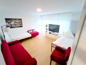 a room with a bed and two chairs and a tv at Ferienwohnung-Montagewohnung 3 in Bad Driburg