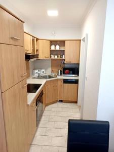 une cuisine avec des armoires en bois et un évier dans l'établissement Ferienwohnung-Montagewohnung 3, à Bad Driburg