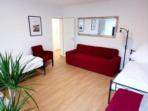 a living room with a red couch and a bed at Ferienwohnung-Montagewohnung 3 in Bad Driburg