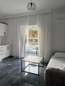 a living room with a bed and a table at Nōya Suites SR in Sarandë