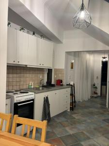 een keuken met witte kasten en een kookplaat oven bij Mountain View Apartment Lefkada in Apolpaina +14 foto's