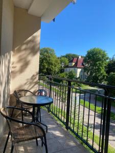 a table and chairs on a balcony with a view at Apartament Olymp 113 z dwoma sypialniami i basenem in Kołobrzeg +11 photos