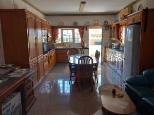 a kitchen with a table and a kitchen with a refrigerator at Vasilis family room in Mor Menekshe