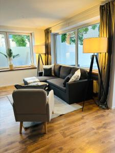 salon z kanapą i krzesłem w obiekcie REMA Homes - Jacuzzi Terrasse 55' TV Küche Regendusche w mieście Bad Bellingen