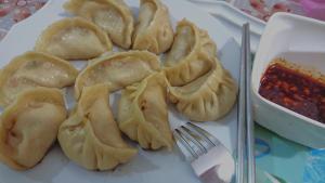 a plate of dumplings on a table with a fork at CANAAN MUSIC Hotel in Moratuwa +56 photos