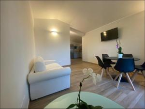a living room with a white couch and a table at Casa vacanze in Quartu SantʼElena