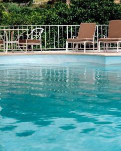 two chairs sitting next to a pool of water at Quinta da Carlota in Torres Vedras