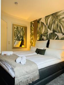 two beds in a bedroom with a painting on the wall at REMA Homes - Moderne Apartments mit Jacuzzi in Bad Bellingen in Bad Bellingen