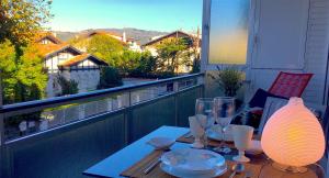 una mesa con copas de vino en el balcón en Apartamento Bahía de Plentzia, en Plentzia