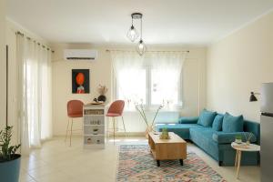 a living room with a blue couch and a table at Feel Like home appartment in Xanthi