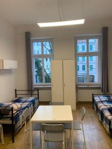 Habitación con camas, mesa y sillas. en Hostel w centrum Szczecina 4 osobowe pokoje, en Szczecin
