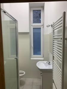 Un baño con lavabo, inodoro y ventana. en Hostel w centrum Szczecina 4 osobowe pokoje, en Szczecin