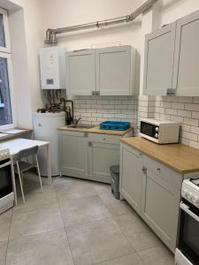 Una cocina con electrodomésticos blancos y una mesa en ella. en Hostel w centrum Szczecina 4 osobowe pokoje, en Szczecin