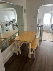 una cocina con 2 mesas de madera en una habitación en Waddon lodge, en Croydon 12 fotos más