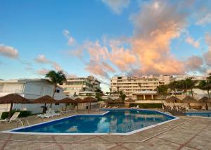 a pool with chairs and umbrellas in a resort at Brisas Shores Beachfront connecting apartments, Cancun Hotel Zone in Cancún