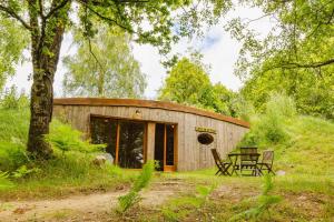 a wooden house with a table and chairs in front of it at KOADOu in Plumeliau Bieuzy