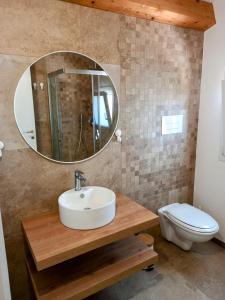 a bathroom with a sink and a mirror and a toilet at Villa Cirasa in Aragona