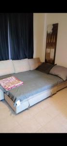 ein großes Bett in einem Zimmer mit einer Couch in der Unterkunft Marassi Lovely 2-Bedroom Chalet in El-Alamein