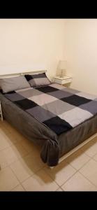 Bett mit einer schwarz-weißen karierten Matratze in der Unterkunft Marassi Lovely 2-Bedroom Chalet in El-Alamein