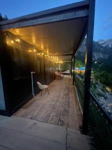 a wooden deck with a chair on top of a building at Guest House Waterfall Theth in Shkodër