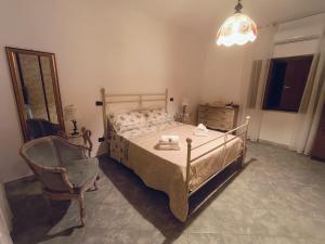 a bedroom with a bed and a chair and a chandelier at Juppi Bed family in Sarnelli
